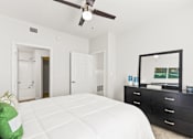 Thumbnail 23 of 57 - a bedroom with a white bed and a ceiling fan
