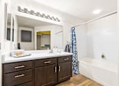 Thumbnail 25 of 57 - a bathroom with a tub and a sink and a mirror