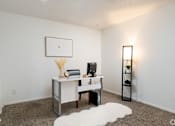 Thumbnail 9 of 28 - A room with a desk, chair, and a white rug.