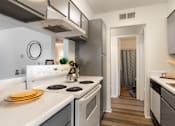 Thumbnail 1 of 28 - A modern kitchen with white appliances and wooden floors.