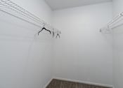 Thumbnail 8 of 28 - Empty white closet with clothes hangers.