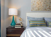 Thumbnail 9 of 44 - A bedroom with a white bed and a blue lamp.