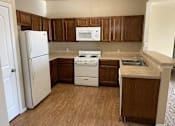 Thumbnail 6 of 18 - A kitchen with wooden cabinets and a white refrigerator.