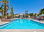 Thumbnail 31 of 57 - a swimming pool with palm trees and a building in the background
