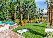 Thumbnail 22 of 50 - A backyard with a white table surrounded by palm trees.