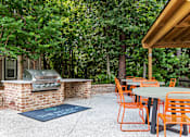 Thumbnail 25 of 50 - A patio with orange chairs and a grill.