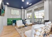 Thumbnail 36 of 50 - A living room with white furniture and a green couch.