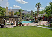 Thumbnail 23 of 32 - A pool area with a bridge and palm trees.