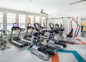 Thumbnail 1 of 31 - A gym with treadmills and exercise bikes.
