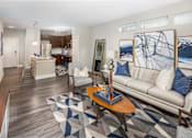 Thumbnail 22 of 31 - A living room with a white couch and a coffee table.