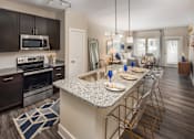 Thumbnail 3 of 31 - An open-concept floor plan with a kitchen island and stainless steel appliances.