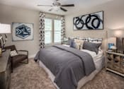 Thumbnail 25 of 31 - A bedroom with a large bed and a ceiling fan.