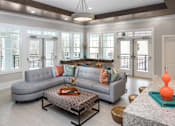Thumbnail 8 of 31 - The clubroom lounge with a grey couch and a coffee table.