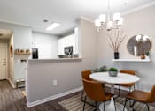 Thumbnail 3 of 41 - A dining room with a white table and brown chairs.