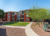 Thumbnail 36 of 41 - Apartment complex with a red brick building and a sidewalk.