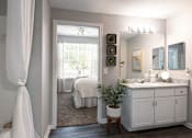 Thumbnail 8 of 41 - A bathroom with a white bed and a white sink.