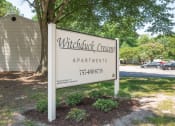 Thumbnail 4 of 13 - a sign for witchcraft crescent apartments in front of a tree