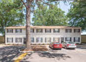Thumbnail 3 of 13 - a large white building with cars parked in front of it