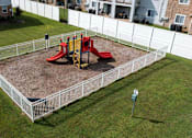 Thumbnail 8 of 30 - a playground in a yard behind a white fence