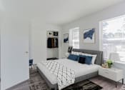 Thumbnail 26 of 30 - a bedroom with white walls and a bed with blue pillows