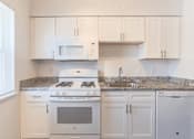 Thumbnail 29 of 30 - a kitchen with white appliances and granite counter tops