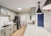 Thumbnail 2 of 28 - a renovated kitchen with white cabinets and a white counter top