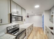 Thumbnail 4 of 28 - a kitchen with white cabinets and stainless steel appliances