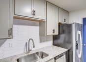 Thumbnail 8 of 28 - a white kitchen with white cabinets and a stainless steel sink