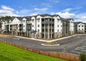 Thumbnail 44 of 50 - an exterior view of an apartment building in a parking lot at Tapestry Overbrook in McDonough, Georgia