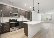 Thumbnail 4 of 50 - kitchen with wood style flooring and stainless steel appliances at Tapestry Overbrook in McDonough, Georgia