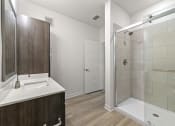 Thumbnail 6 of 50 - bathroom with quartz countertops, designer lighting, and undermount sinks at Tapestry Overbrook in McDonough, Georgia