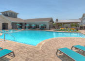 Thumbnail 21 of 34 - a resort style pool with lounge chairs and umbrellas