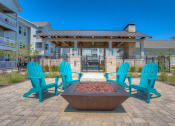 Thumbnail 23 of 34 - a firepit with blue adirondack chairs sits in the middle of a brick patio