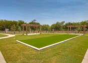 Thumbnail 25 of 34 - a grassy area with two pergolas in the background