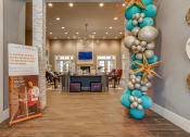 Thumbnail 19 of 34 - a large balloon column in the lobby of a home with a reception desk in the background