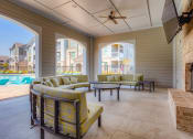 Thumbnail 14 of 34 - a covered patio with couches and a fireplace