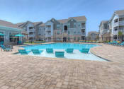 Thumbnail 1 of 34 - a resort style swimming pool with chaise lounge chairs and umbrellas