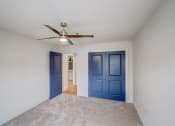 Thumbnail 12 of 28 - a empty room with blue doors and a ceiling fan