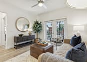 Thumbnail 7 of 39 - a living room with french doors and ceiling fan at Tapestry Headwaters in Kissimmee, FL
