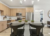Thumbnail 6 of 39 - island kitchen with modern lighting at Tapestry Headwaters in Kissimmee, FL