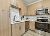Thumbnail 3 of 39 - Modern Kitchen with Subway Tile Backsplash and Gooseneck Pulldown Sprayer at Tapestry Headwaters in Kissimmee, FL