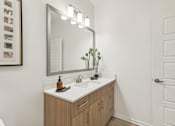 Thumbnail 18 of 39 - a bathroom with a undermount sink and designer lighting at Tapestry Headwaters in Kissimmee, FL