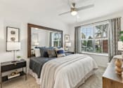 Thumbnail 10 of 39 - Primary bedroom with large window and ceiling fan at Tapestry Headwaters Apartments in Kissimmee, FL