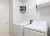 Thumbnail 15 of 25 - a washer and dryer in a white laundry room with a shelf over the