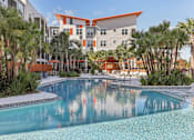 Thumbnail 2 of 39 - Swimming Pool with Seating and Umbrellas at Tapestry Headwaters in Kissimmee, FL