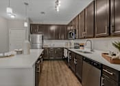 Thumbnail 4 of 38 - an empty kitchen with wooden cabinets and stainless steel appliances