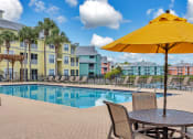 Thumbnail 23 of 35 - tables and umbrellas with seating at Bermuda Estates Apartments in Ormond Beach, FL