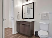 Thumbnail 18 of 55 - A bathroom with a white countertop, high ceilings, tile shower surround and luxury LVP floors