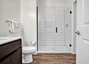 Thumbnail 19 of 55 - A modern bathroom with white countertops and walk-in shower with tile surround