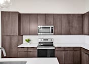 Thumbnail 3 of 55 - A modern kitchen with dark wood cabinets and white countertops.